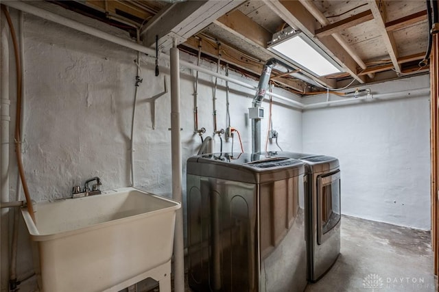 washroom featuring a sink, laundry area, and washer and dryer