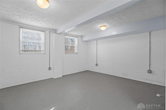 below grade area featuring concrete block wall and a textured ceiling