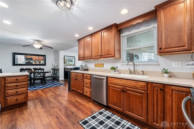 kitchen with light countertops, dark wood-type flooring, brown cabinetry, a sink, and dishwasher