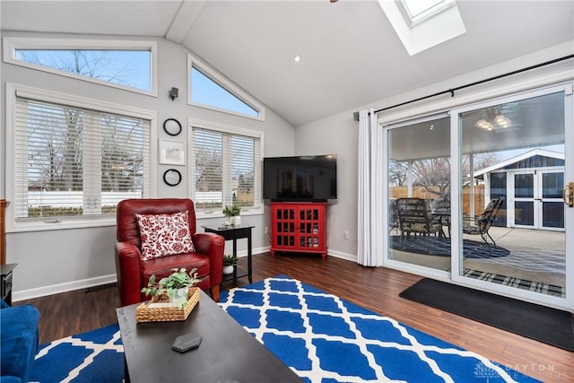 sitting room featuring vaulted ceiling with skylight, baseboards, and wood finished floors