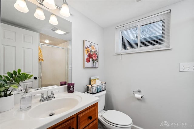 bathroom featuring a stall shower, vanity, and toilet