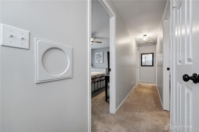 hallway featuring baseboards and carpet flooring