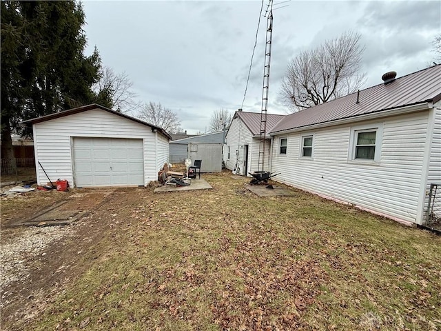 view of yard with an outbuilding, driveway, and a detached garage