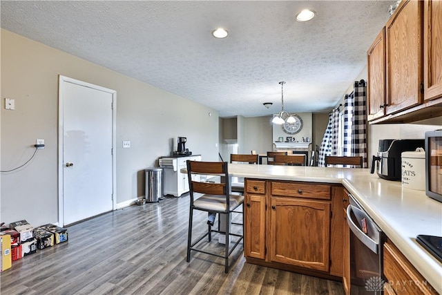 kitchen with dark wood-style flooring, brown cabinets, light countertops, dishwasher, and a peninsula