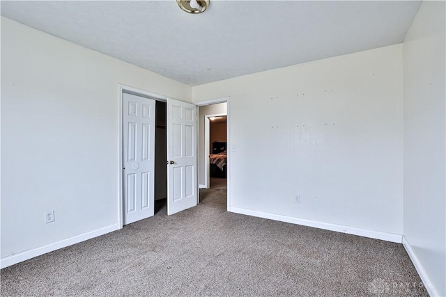 unfurnished bedroom with carpet floors, a closet, and baseboards