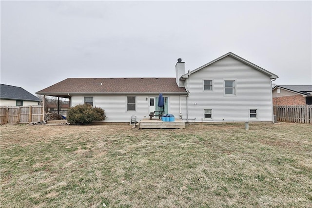 rear view of property featuring a fenced backyard, a chimney, a deck, and a yard