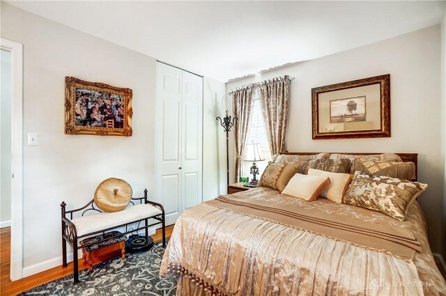 bedroom with a closet, baseboards, and wood finished floors