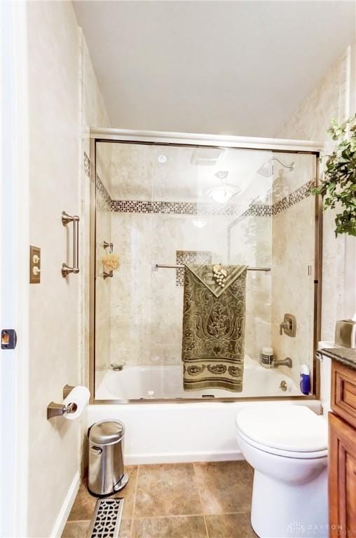 bathroom featuring toilet, shower / bath combination with glass door, tile patterned flooring, and vanity