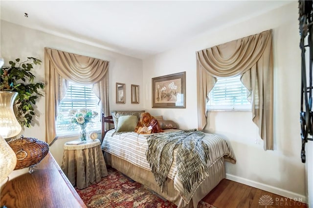 bedroom with baseboards and wood finished floors