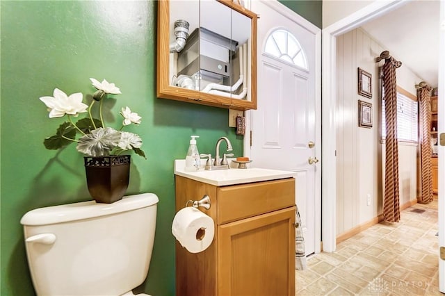 bathroom with baseboards, vanity, and toilet