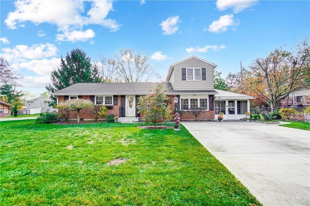 view of front facade featuring concrete driveway, brick siding, a front lawn, and a sunroom