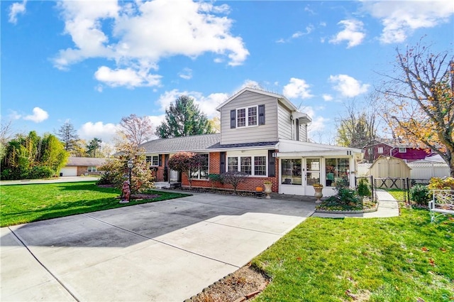 view of front facade featuring a gate, fence, a front lawn, and brick siding