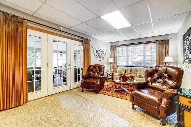 living area with french doors and a paneled ceiling