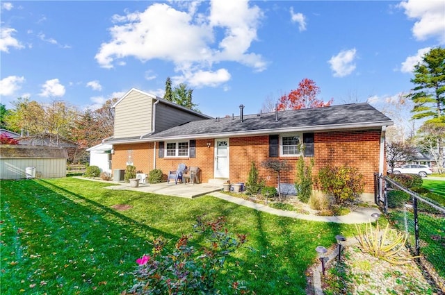 back of house with a patio, cooling unit, brick siding, fence, and a lawn