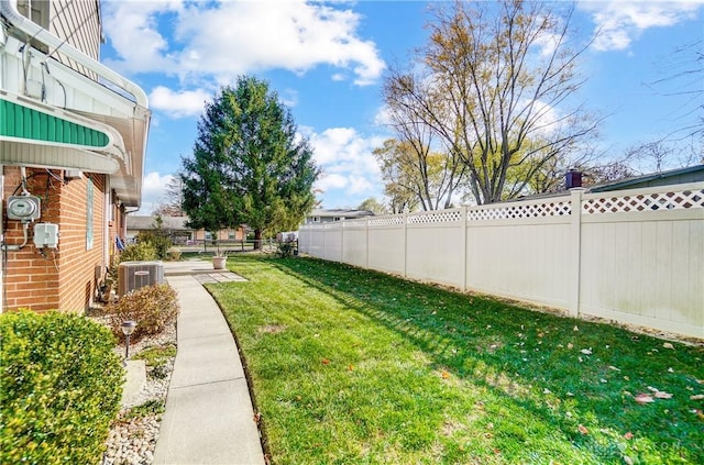 view of yard with a fenced backyard and central air condition unit