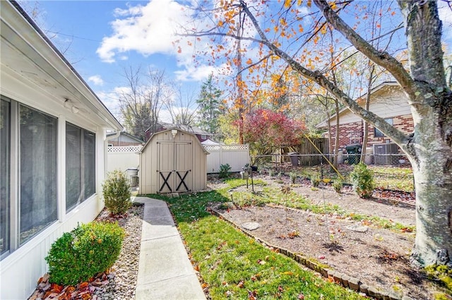 view of yard with a storage shed, an outbuilding, a fenced backyard, and a sunroom