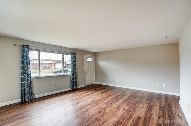 empty room with baseboards and wood finished floors