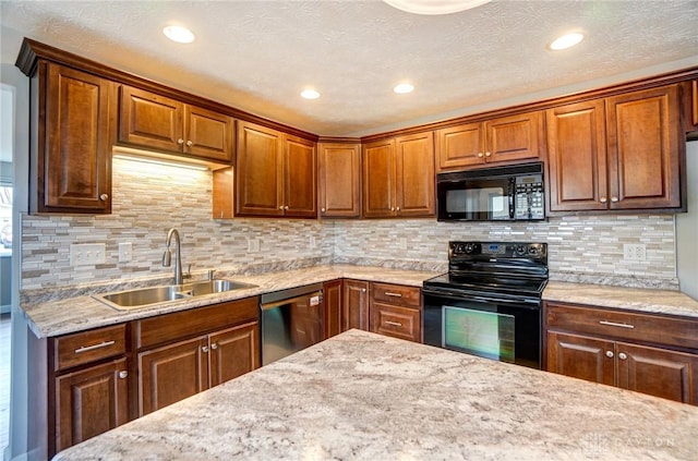 kitchen featuring light stone counters, recessed lighting, decorative backsplash, a sink, and black appliances