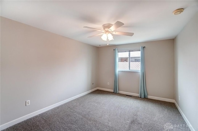 carpeted empty room featuring a ceiling fan, visible vents, and baseboards