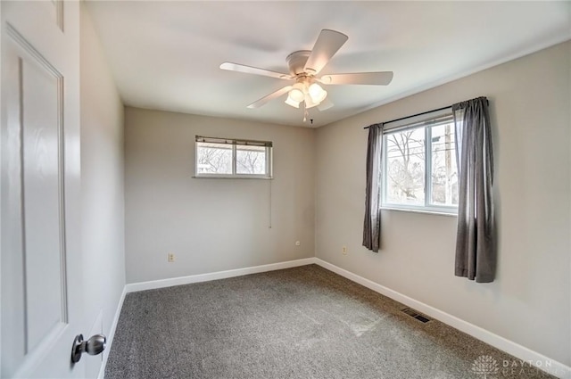 unfurnished room with a ceiling fan, baseboards, visible vents, and carpet flooring