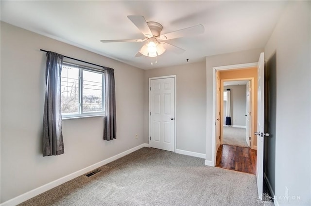 unfurnished bedroom with carpet floors, baseboards, visible vents, and ceiling fan