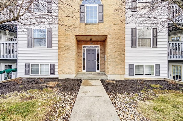 view of exterior entry featuring brick siding