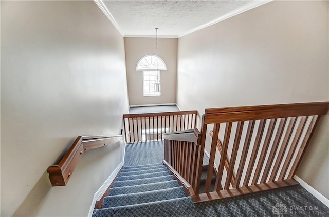 stairway with ornamental molding, carpet floors, a textured ceiling, and baseboards