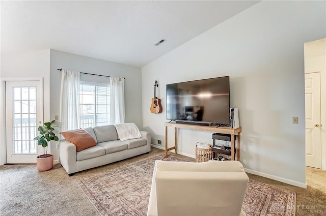 living area with carpet, visible vents, lofted ceiling, and baseboards