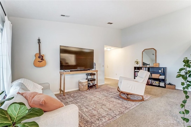 carpeted living area with lofted ceiling, visible vents, and baseboards