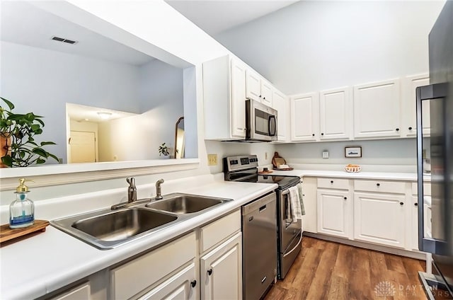 kitchen featuring stainless steel appliances, white cabinets, light countertops, and a sink