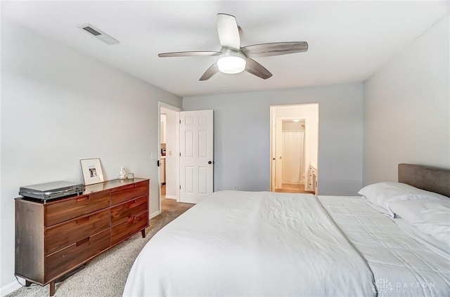 bedroom featuring carpet floors, visible vents, a ceiling fan, ensuite bath, and baseboards