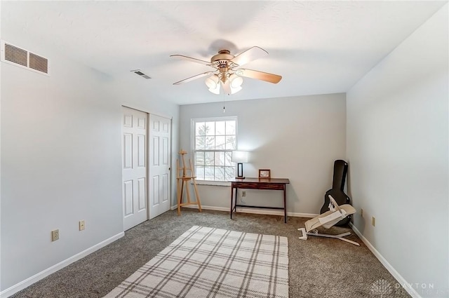 interior space with light carpet, baseboards, visible vents, and a ceiling fan