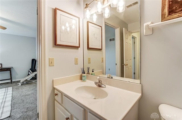 half bath featuring toilet, visible vents, and vanity