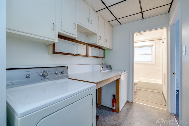 washroom with washer / dryer, cabinet space, and light tile patterned floors