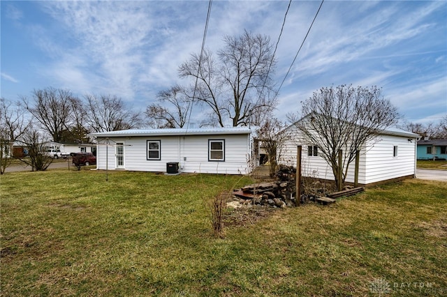 back of house featuring central air condition unit and a yard