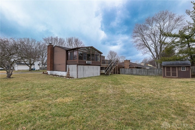 view of yard with an outdoor structure, fence, a sunroom, stairs, and a shed