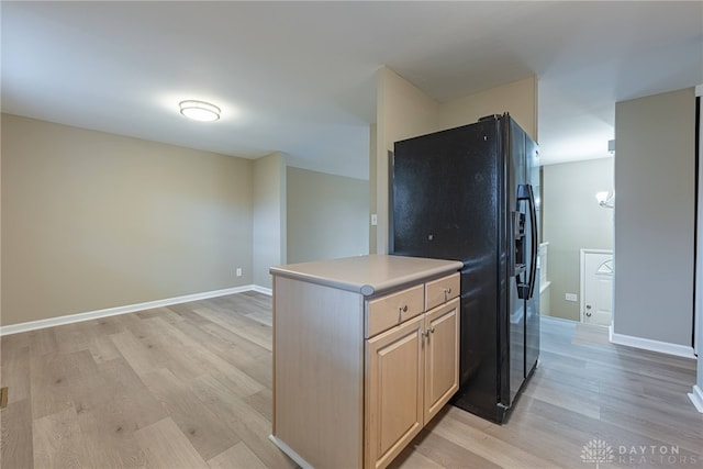 kitchen with light wood finished floors, baseboards, black fridge with ice dispenser, light countertops, and light brown cabinetry