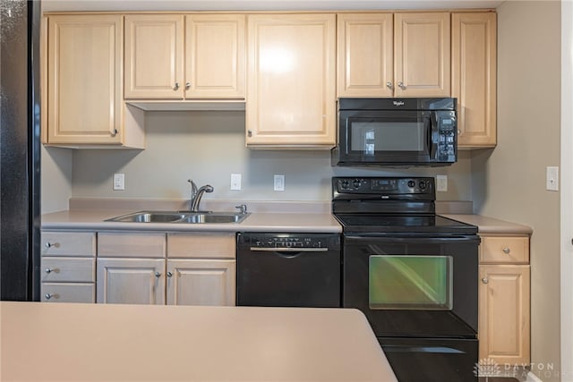 kitchen with black appliances, a sink, and light countertops