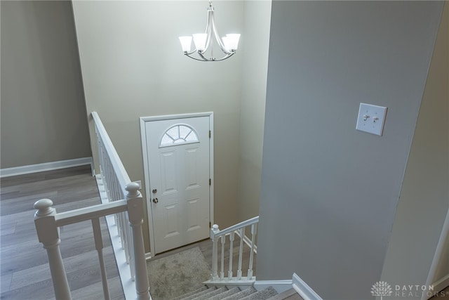 foyer featuring a chandelier, baseboards, and wood finished floors