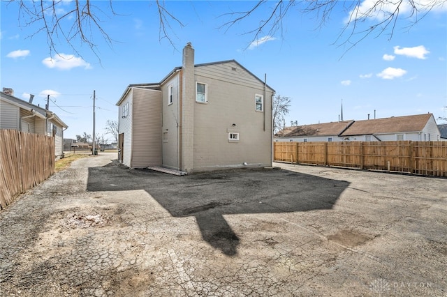 rear view of house featuring fence