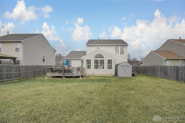 back of property featuring a storage shed, a fenced backyard, a deck, a yard, and an outdoor structure