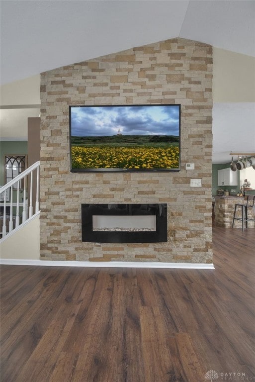 interior details featuring wood finished floors and a stone fireplace