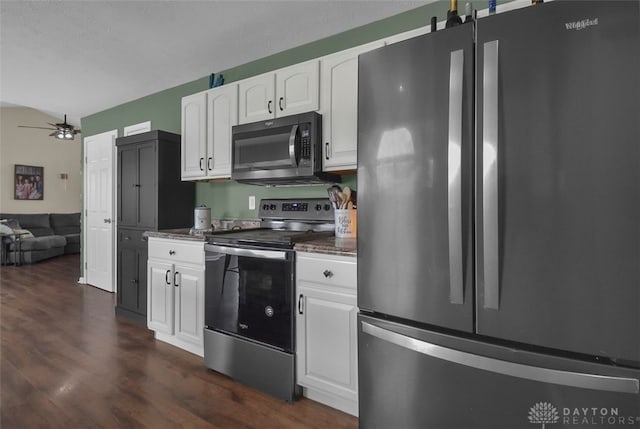 kitchen with dark wood-type flooring, white cabinetry, stainless steel appliances, and a ceiling fan