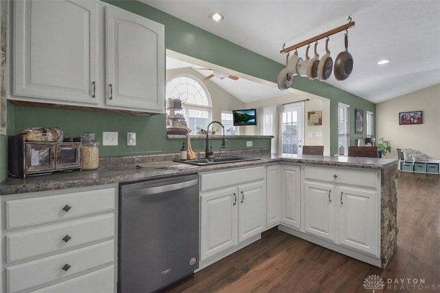 kitchen featuring lofted ceiling, a sink, a peninsula, and stainless steel dishwasher