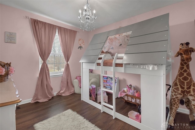 bedroom featuring baseboards, a chandelier, and wood finished floors