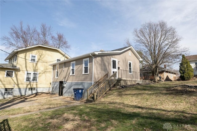 rear view of property featuring a lawn