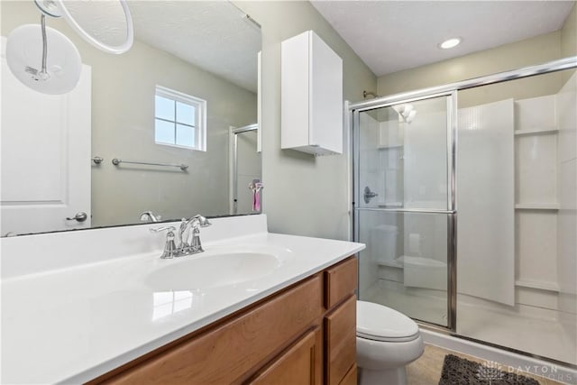 bathroom featuring toilet, a shower stall, and vanity