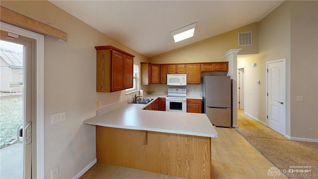 kitchen featuring a peninsula, white appliances, a sink, visible vents, and light countertops