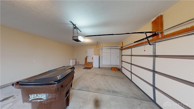 garage with a garage door opener and freestanding refrigerator