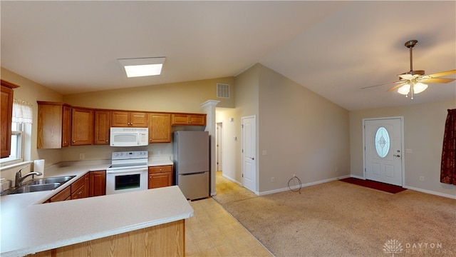 kitchen featuring white appliances, a sink, visible vents, vaulted ceiling, and light countertops